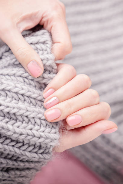 istock Female hands holding large gray woolen scarf. Top view 1284220081