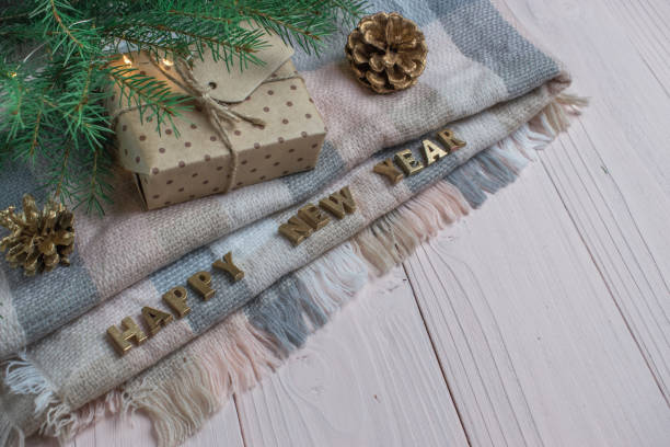 istock Wooden background with a warm blanket and gold letters and a gift box. Space for text. 1284220968
