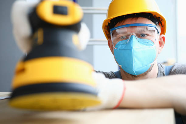 istock Guy in a helmet and safety glasses with a sander 1284223872