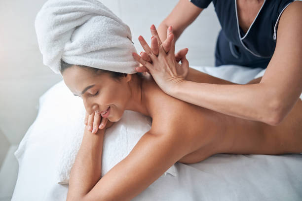 istock Charming young woman enjoying back massage in spa salon 1284223940