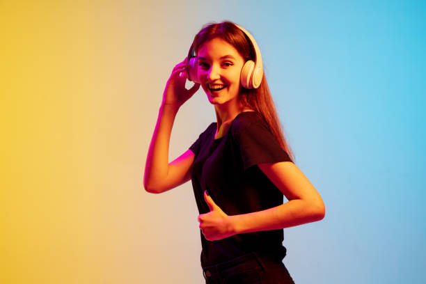 istock Young caucasian woman's portrait on gradient blue-yellow studio background in neon light 1284225116