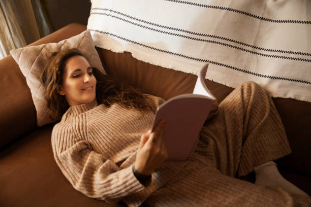 istock Girl reading on the sofa at home 1284226222