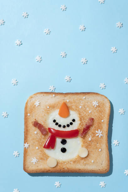 Desayuno navideño: tostadas con clara de huevo en forma de muñeco de nieve - foto de stock