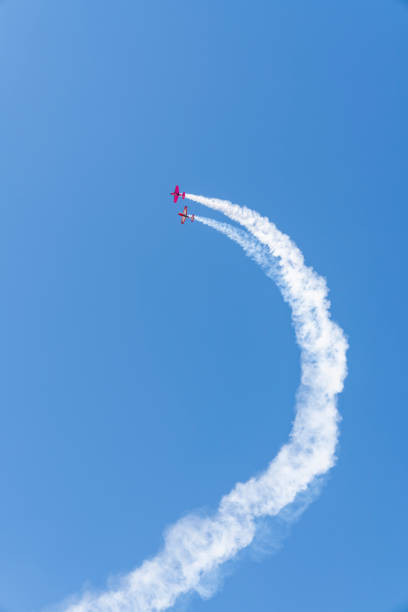 빈티지 복엽비행기는 연기 트레일로 스턴트를 반복합니다. 오래된 비행기 - biplane airshow airplane performance 뉴스 사진 이미지