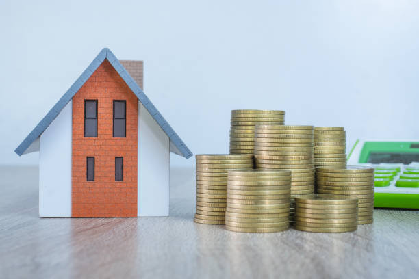house and pile of coins the idea of saving money, buying a house and mortgage, real estate and investing in buying a house, renting, paying taxes. - real estate imagens e fotografias de stock