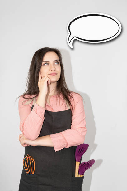 istock young beautiful housewife with empty think clouds, concept - What to cook today? 1284230121