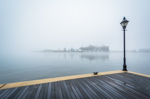Pier with people in distance on a foggy day.