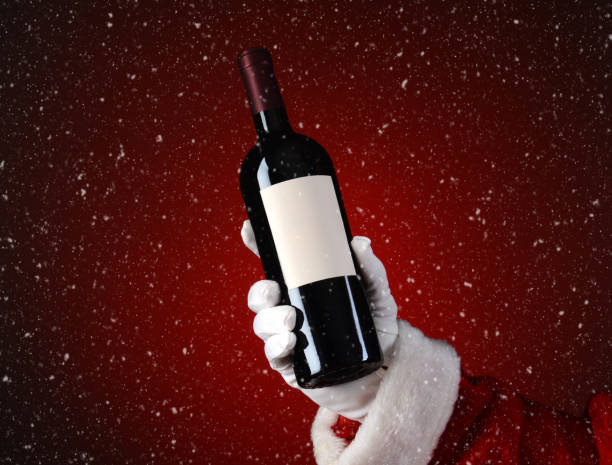 bouteille de vin de maintien de santa avec l’effet de neige - christmas santa claus gift holding photos et images de collection