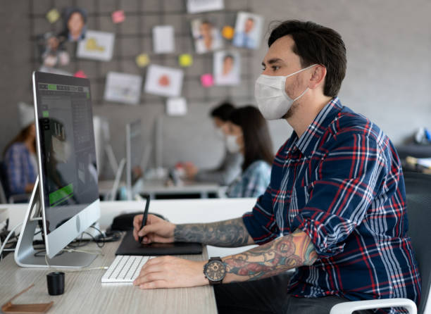 istock Graphic designer working at a creative office wearing a facemask 1284233040
