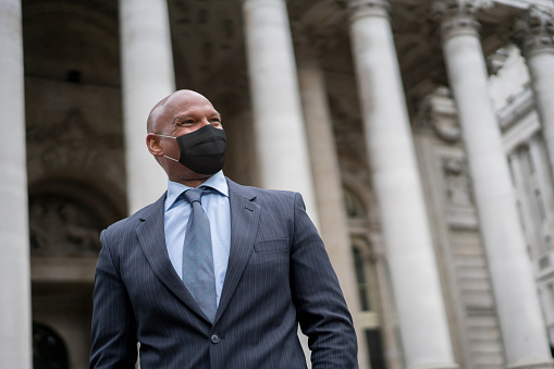Portrait of an African American business man wearing a facemask outside an office building during the COVID-19 pandemic
