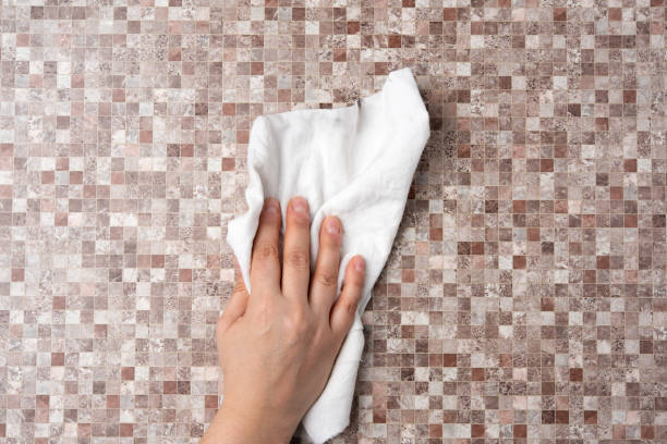 istock female hand wipes a brown table with a white rag 1284234996