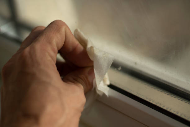 istock The hand wipes the window. Washing windows from marks on glass. 1284236413