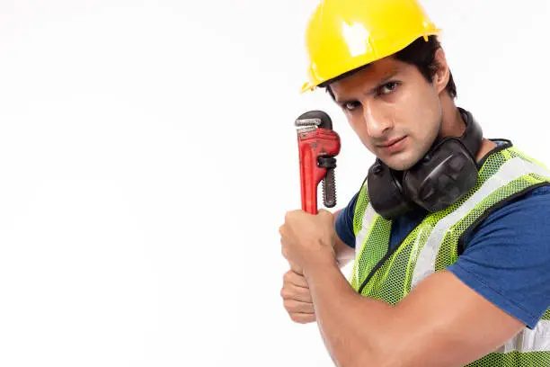 Industrial engineer man ready to fighting with hardwork. Worker man wear hardhat, reflective vest. Handsome industry engineer guy work in industry manufacturing factory. He get determined. copy space