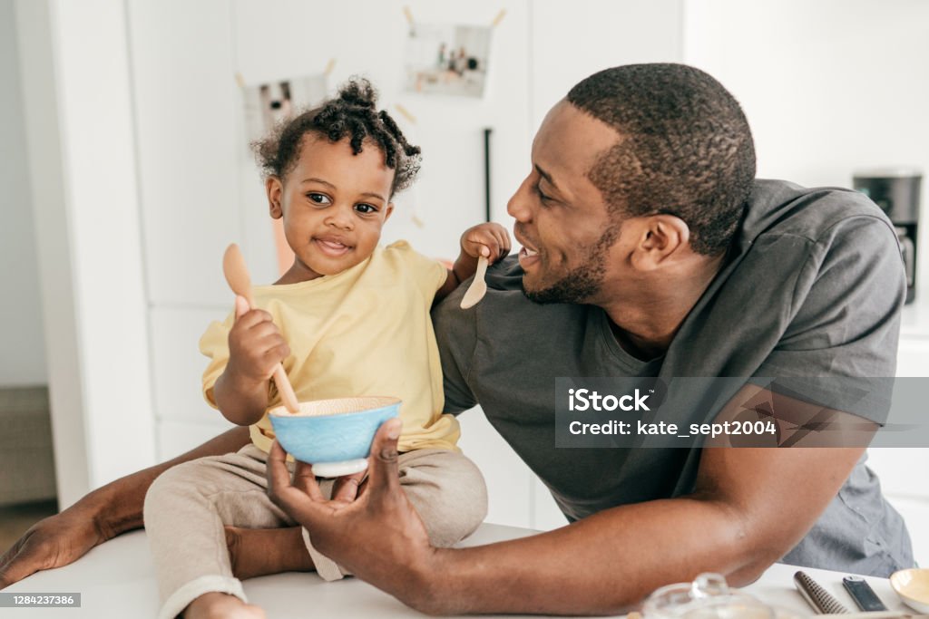 Dad and toddler eating snacks 12-17 Months Stock Photo