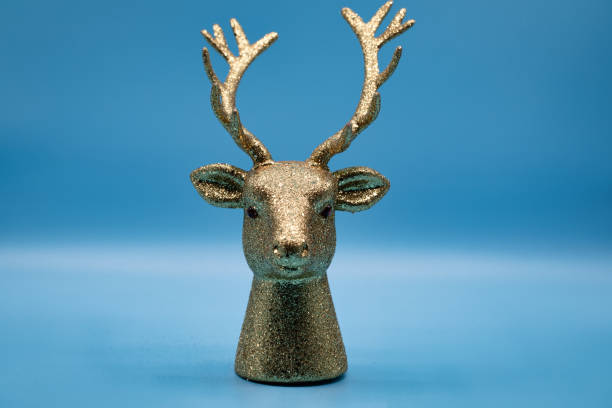 golden deer on blue background. Glowing Christmas Reindeer Design With copy space. Background Christmas decorations