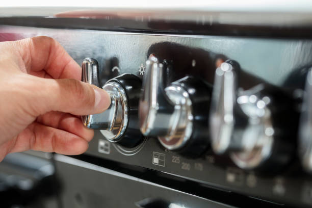 Commercial kitchen stove temperature controls on cooker hob Commercial kitchen stove temperature controls on cooker hob with chef turning knob knob stock pictures, royalty-free photos & images