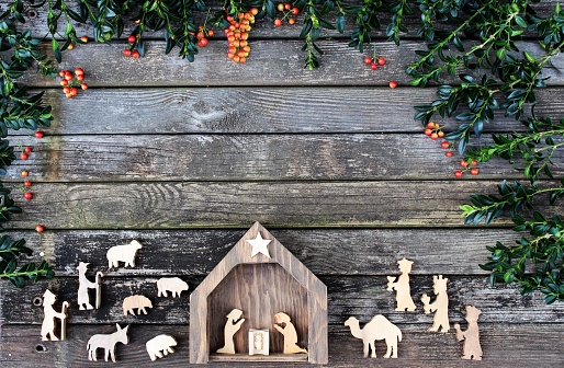 christmas holiday nativity scene with figures and a manger animals and baby jesus in a rustic wood background setting