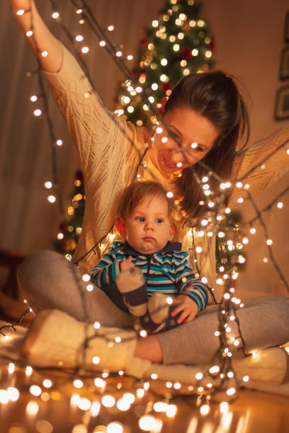 istock Mother and child playing with Christmas lights 1284241653