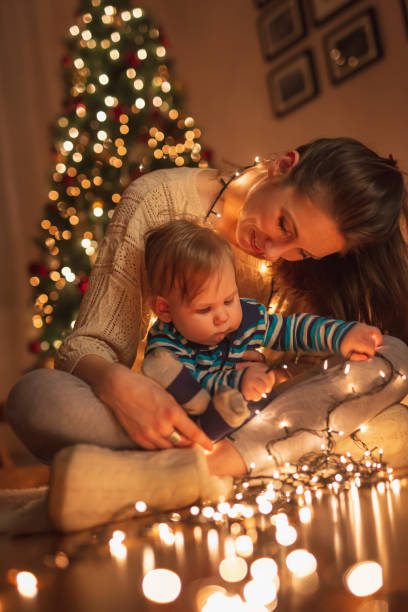 istock Mother and baby boy playing with Christmas lights 1284241668