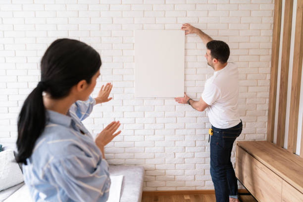 istock Young couple putting painting on the wall 1284242509