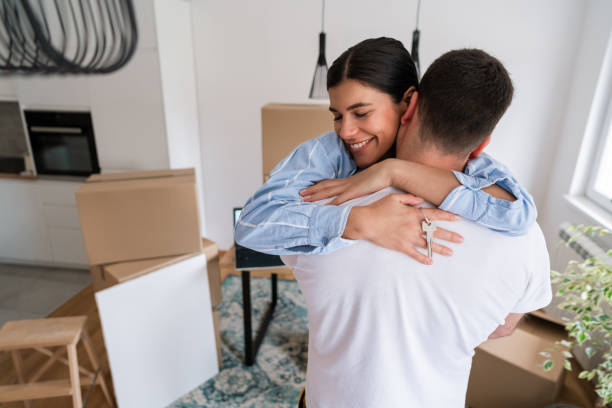istock Smiling woman hugging man and holding home keys 1284242516