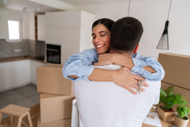 istock Smiling woman holding home keys and hugging man 1284242517
