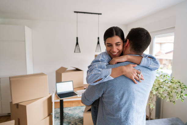 istock Happy woman hugging man and holding home keys 1284242519