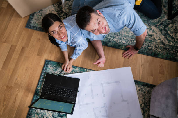 istock High angle view of a young  couple using laptop at home during renovation day and looking at camera 1284242531