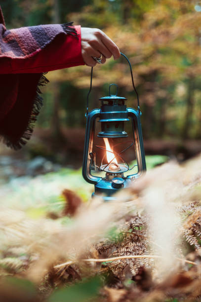 istock Close-up Of A Female Hand Holding An Old Lantern In The Forest 1284242566