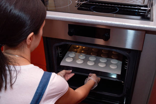 istock The girl puts a baking tray with macaroons to bake. Cooking process. 1284243106