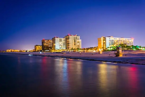 View of beachfront hotels and the beach from the fishing pier at night in Clearwater Beach, Florida