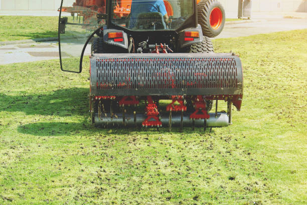 gardener operating soil aeration machine on grass lawn - aeration imagens e fotografias de stock