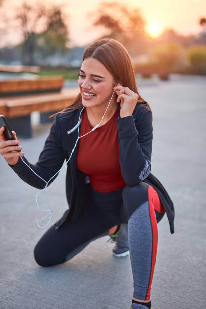 istock Modern young woman with cellphone making pause during jogging / exercise. 1284245022