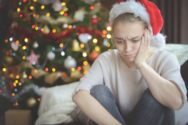 istock young woman in christmas interior ( negative emotions) 1284245194