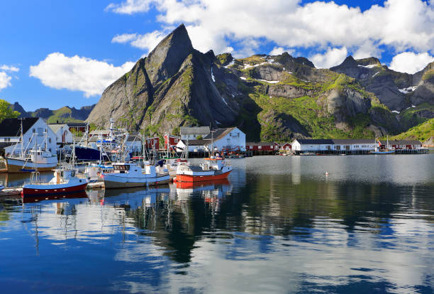 montanhas afiadas e barcos de pesca refletidos no fiorde em hamnoy, ilhas lofoten - northern atlantic - fotografias e filmes do acervo