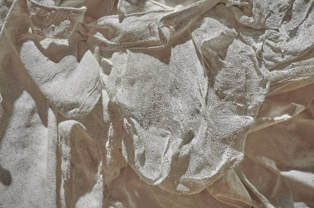 istock Fabric texture, soft, low-contrast, slightly toned conceptual image of white fabric prepared in plaster solution, low warm toning, specially crumpled, selective sharpness 1284249554