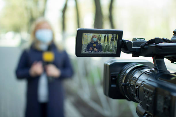 A female journalist in a protective medical mask is reporting in a deserted city. stock photo