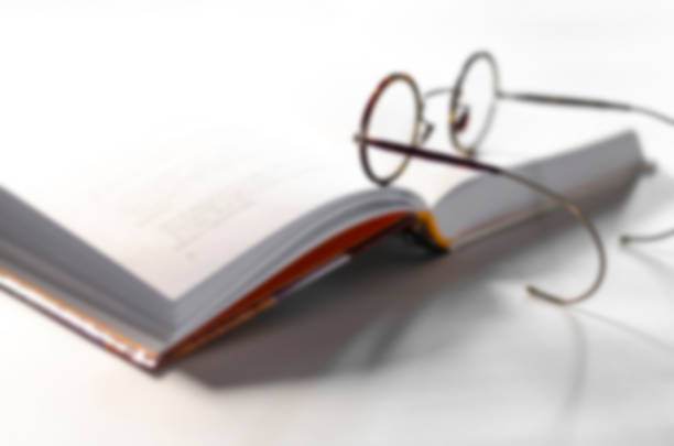 istock Blurred. Old round reading glasses lie on an open book ready to read. The cozy concept 1284251514