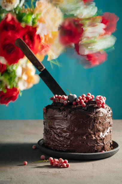 istock Chocolate cake with red currant frozen berries on top and cutting knife 1284252961