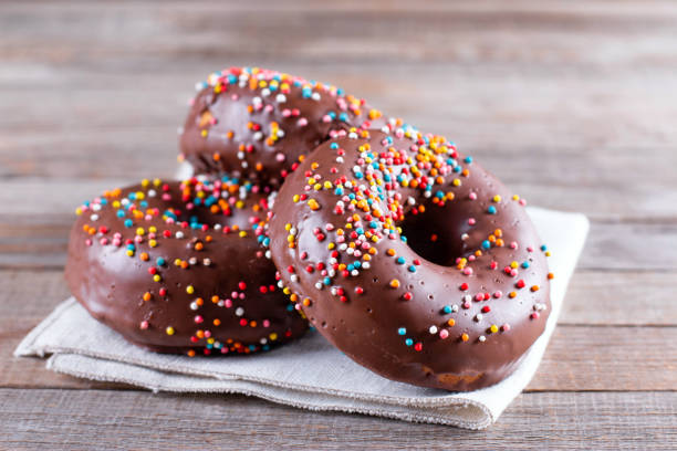 istock Baked chocolate doughnuts with chocolate glaze on a table 1284253074