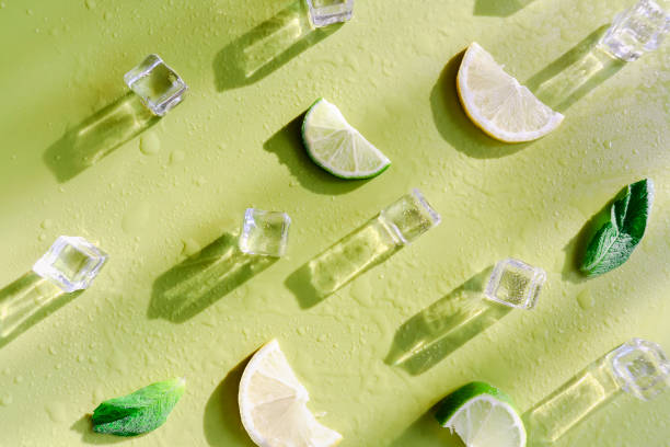 istock Fresh mint leaf and ice cubes with droplets and lime on green background 1284253873