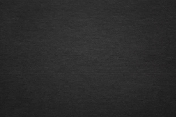istock Texture of black fibrous paper, cardboard, closeup. Solid background, embossed surface. 1284255716