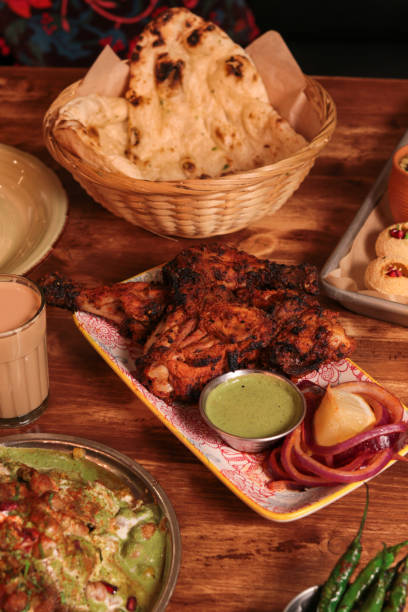 Indian Food Dinner with BBQ Tandoori Chicken and naan bread Indian Food Dinner with BBQ Tandoori Chicken and naan bread with lassi silver platter stock pictures, royalty-free photos & images