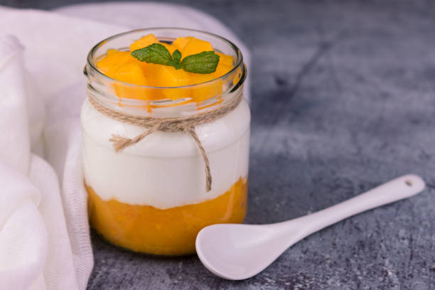 istock Jar of Limitated Greek Yogurt with Mango Puree. Close-up. 1284256817