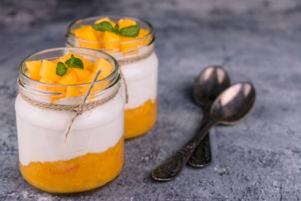 istock Greek yogurt with mango puree in a jar. Close-up. 1284256831