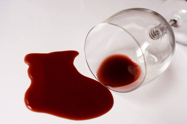 istock Glass with spilled red wine on a white background. Close-up. 1284256910