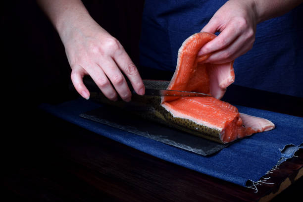 istock Cook is cutting carcass of a red fish with a knife 1284258235