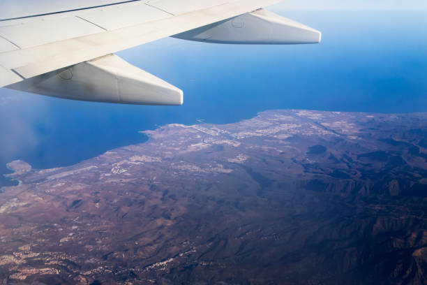 Airplane wing over an island in the atlantic ocean