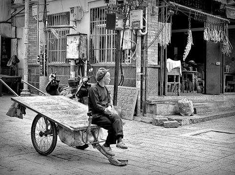 Man sitting on a cart at Dali ancient city, Yunnan province, China.
