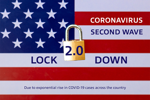 Concept Of Second Lockdown in US. Real padlock placed on top of the American flag to indicate second national lockdown in US due to rise in COVID-19 cases.